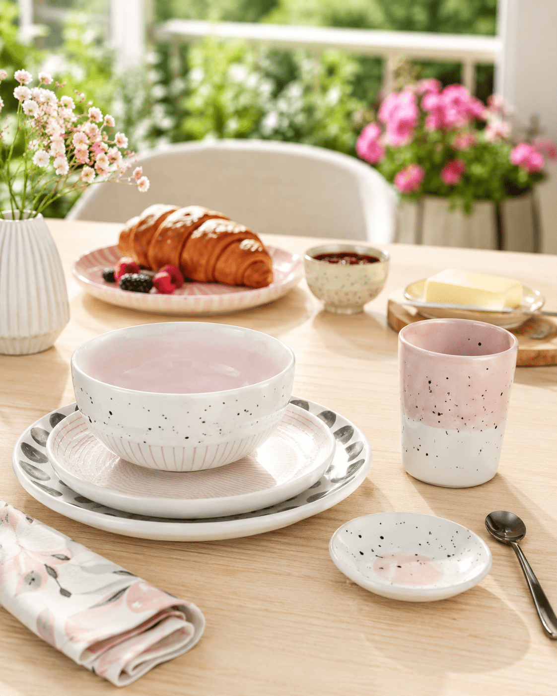 Handgemachte rosa Keramik mit Tumbler und Schale auf sonnigem Balkontisch, KI-Produktbild für Keramik-Manufakturen